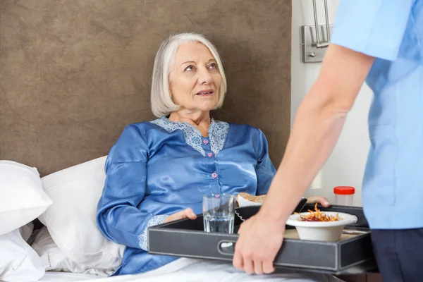 Krankenschwester serviert Seniorin Frühstück — Stockfoto