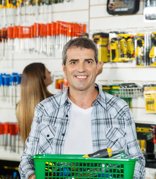 Mann trägt Korb voller Werkzeuge im Geschäft — Stockfoto