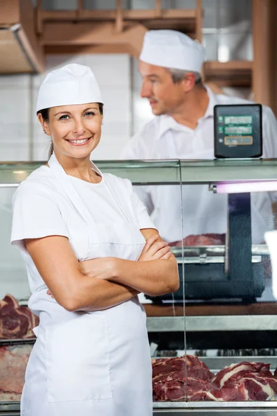 Säker slaktare med kollega arbetar i butik — Stockfoto