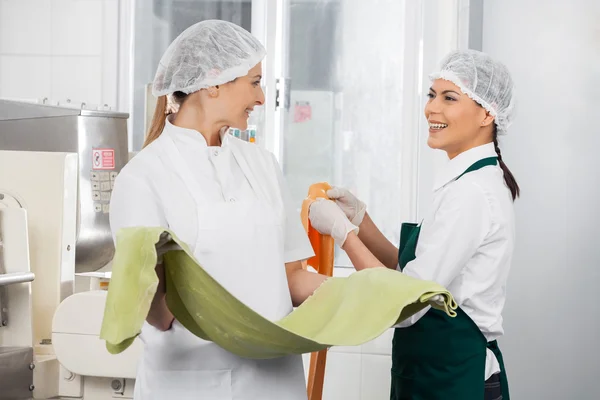 Chefs felizes conversando enquanto segurando folhas de massas — Fotografia de Stock