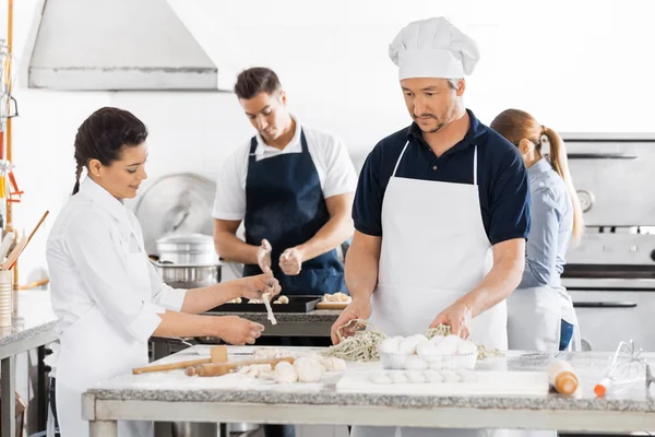 Chefs preparando massas em balcões de cozinha — Fotografia de Stock