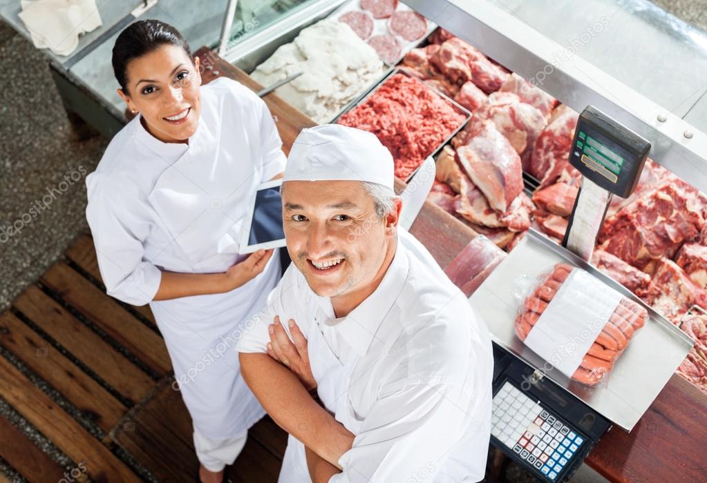 Happy Butchers Standing At Butchery Counter