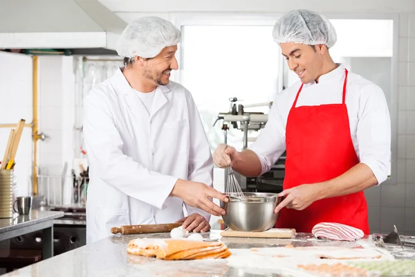 Happy Chefs Discussing While Preparing Ravioli Pasta In Kitchen — Stock Photo, Image