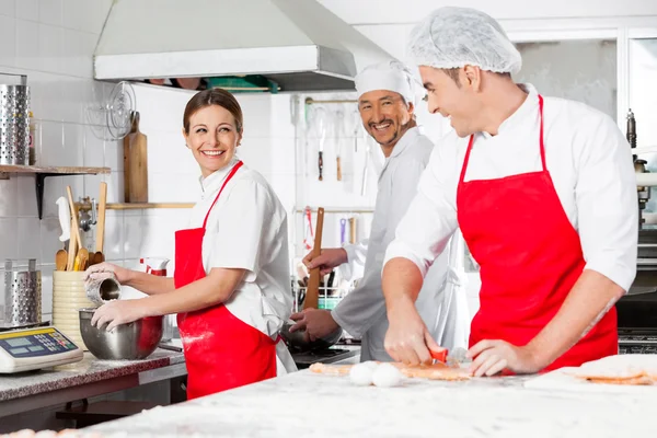 Chefs felizes conversando na cozinha comercial — Fotografia de Stock