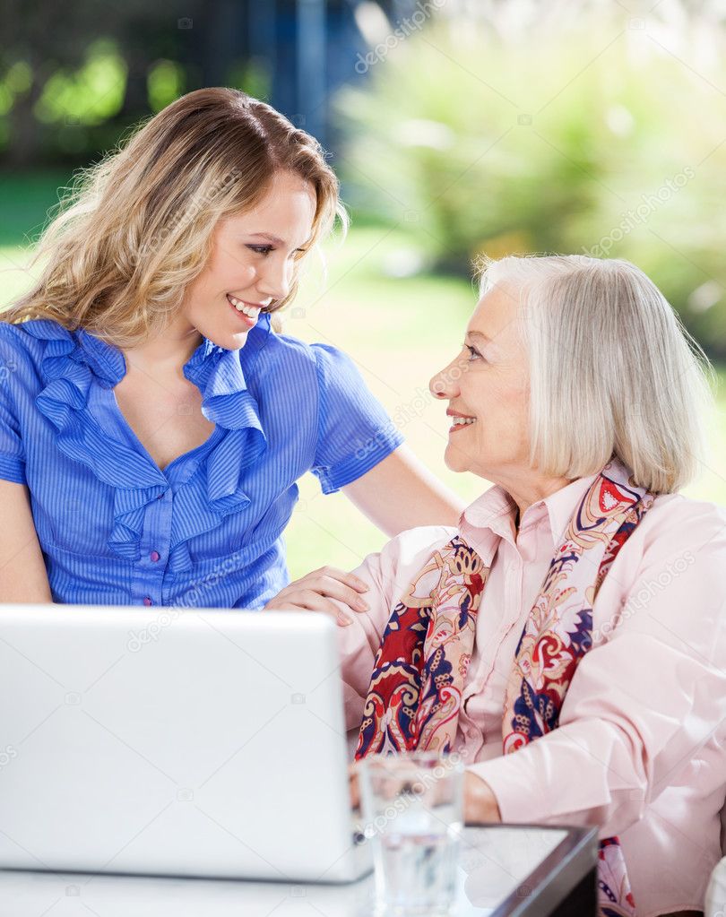 Happy Granddaughter And Grandmother With Laptop On Porch