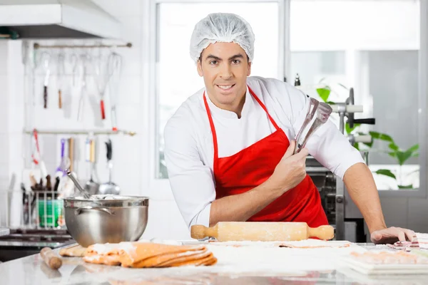 Уверенный шеф-повар держит щипцы во время приготовления пасты Равиоли Ин Ки — стоковое фото