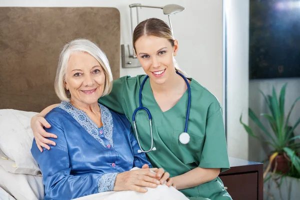 Glücklicher Hausmeister mit Arm um Seniorin im Pflegeheim — Stockfoto