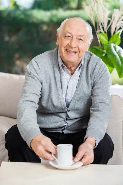 Senior Man met koffie op verpleeghuis veranda — Stockfoto