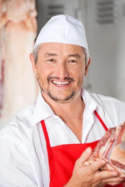 Portrét řezníka, drží maso — Stock fotografie