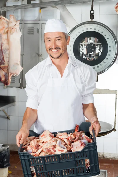 Metzger trägt Kiste voller Fleischstücke — Stockfoto