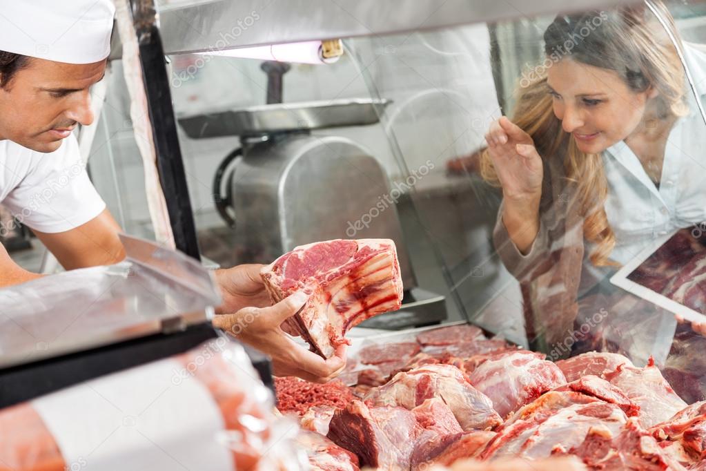 Woman Buying Meat At Butchery — Stock Photo © SimpleFoto 61785257