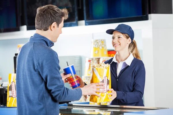 Продавець дарує попкорн і п'є людині під час концесії — стокове фото