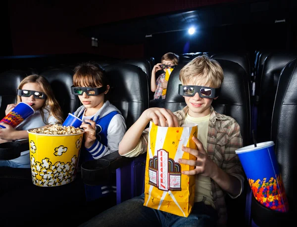 Irmãos fazendo lanches no cinema 3D — Fotografia de Stock