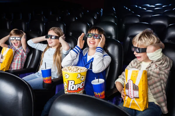 Братья и сёстры наслаждаются 3D фильмом в театре — стоковое фото