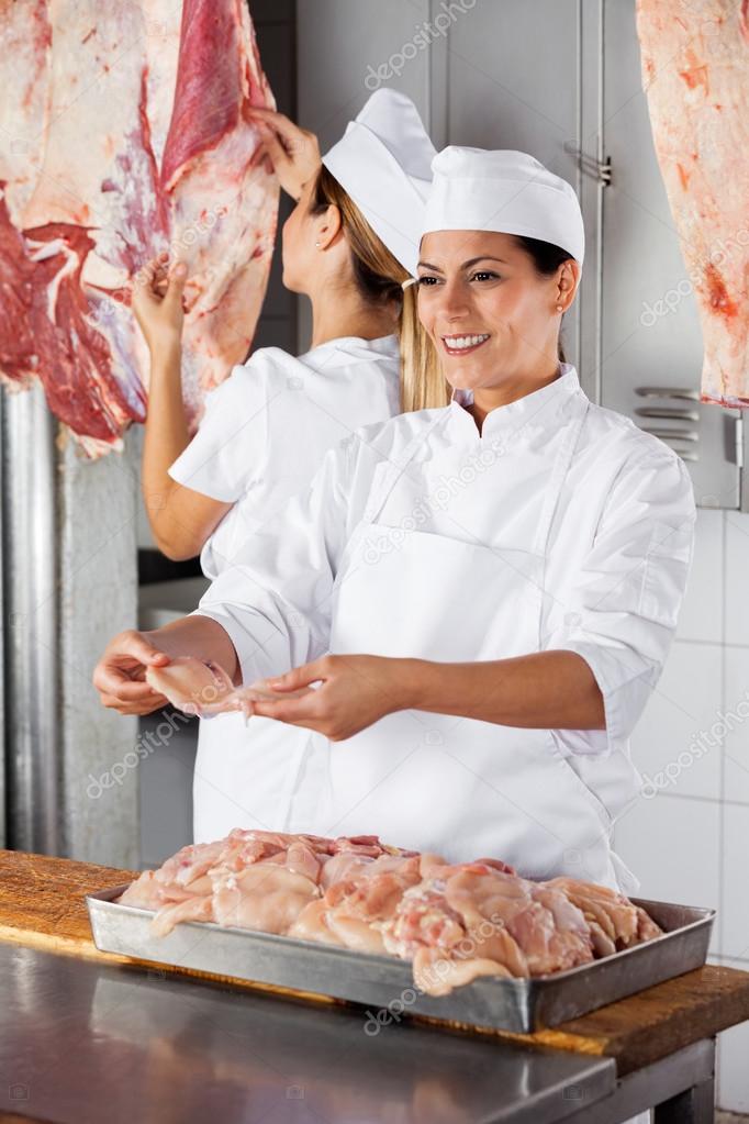 Female Butcher Giving Raw Meat In Shop
