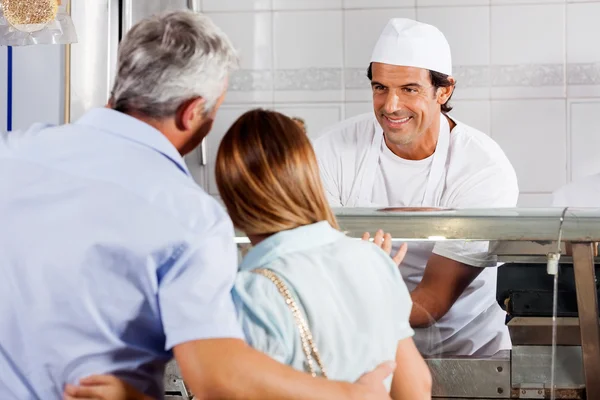 Butcher Looking At Customers In Shop — Stock Photo, Image
