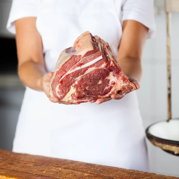 Sección media del carnicero sosteniendo trozo de carne — Foto de Stock