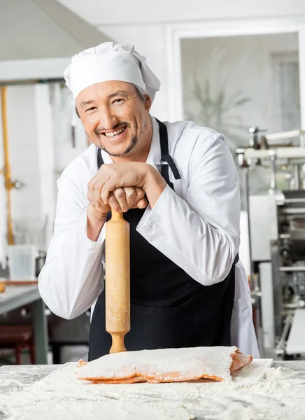 Chef segurando o rolo do pino no balcão na cozinha — Fotografia de Stock