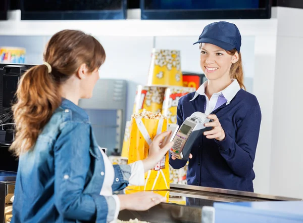 Trabajador aceptando el pago de la mujer a través de la tecnología NFC en Ci —  Fotos de Stock