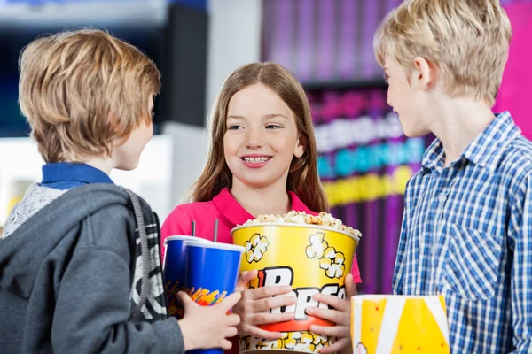 Siblings Conversing While Holding Snacks At Cinema — Stock Photo, Image