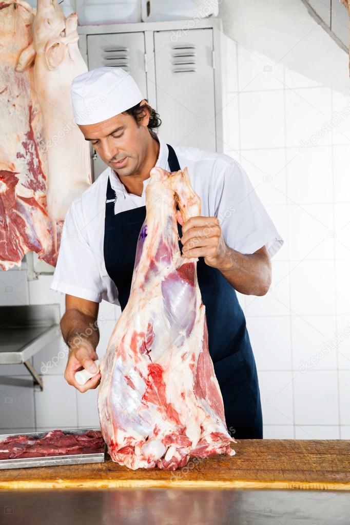 Butcher With Meat Working At Counter