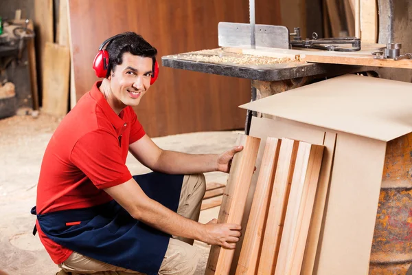 Tischler arrangiert Holzbohlen in Werkstatt — Stockfoto