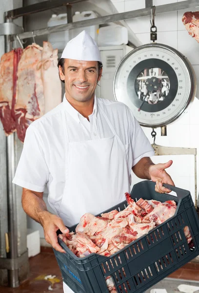 Metzger trägt Kiste voller Fleischstücke — Stockfoto