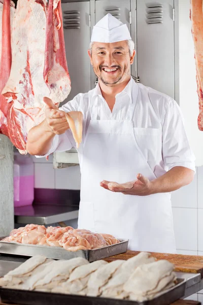 Carnicero feliz mostrando trozo de pollo — Foto de Stock
