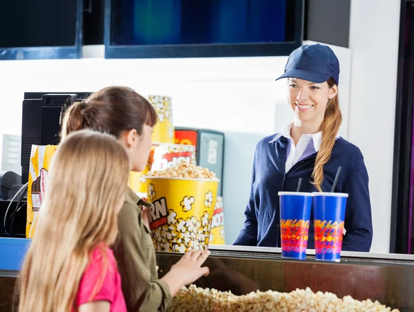 Ragazze che comprano spuntini da venditore femminile allo stand di concessione — Foto Stock