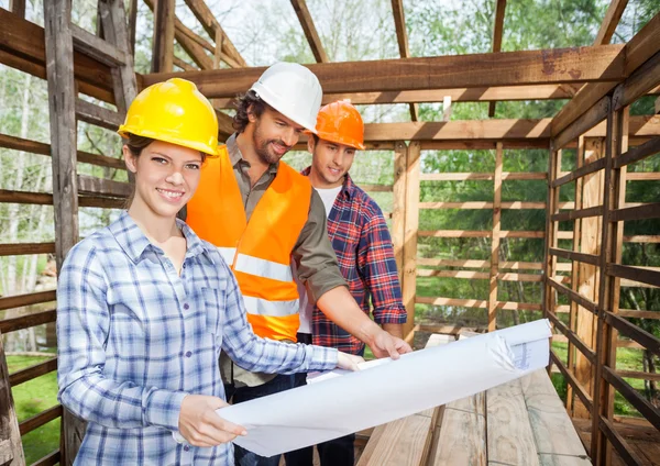 Arquitecto seguro con colegas examinando el plano en el sitio —  Fotos de Stock