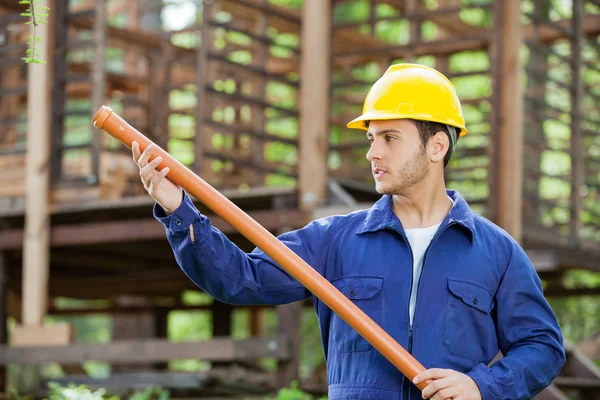 Dělník, zkoumání potrubí na staveništi — Stock fotografie