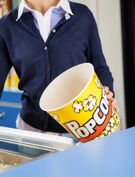 Obrero sosteniendo cubo de palomitas vacías en el stand de concesión —  Fotos de Stock