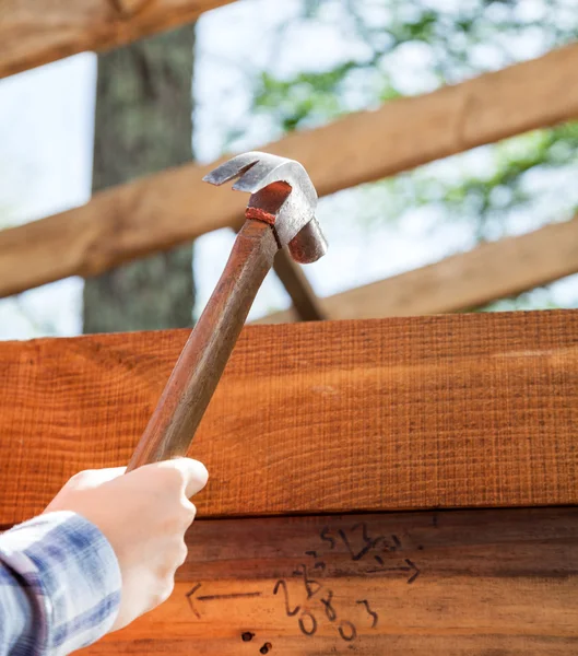 Lavoratori mano martellante chiodo sul telaio in legno in loco — Foto Stock