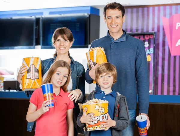 Familie hält Popcorn und Getränke im Kino — Stockfoto