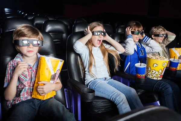 Crianças assustadas assistindo filme 3D no cinema — Fotografia de Stock