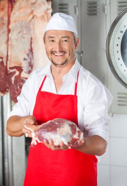 Erkek kasap et deposunda tutan gülümseyerek