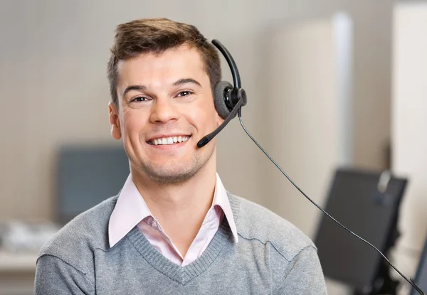 Representante de atendimento ao cliente usando fone de ouvido enquanto sorri em — Fotografia de Stock