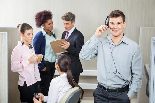 Représentant du service à la clientèle masculin heureux utilisant des écouteurs — Photo