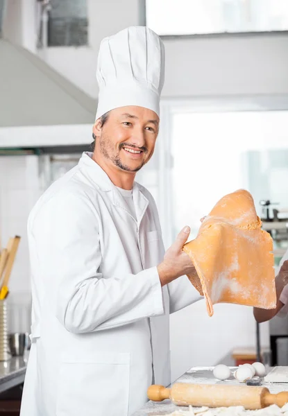 Felice Chef Holding Ravioli foglio di pasta in cucina — Foto Stock