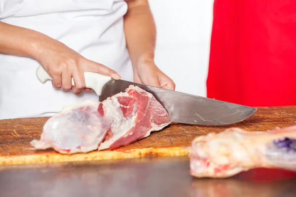 Macellaio femminile che taglia carne fresca cruda — Foto Stock