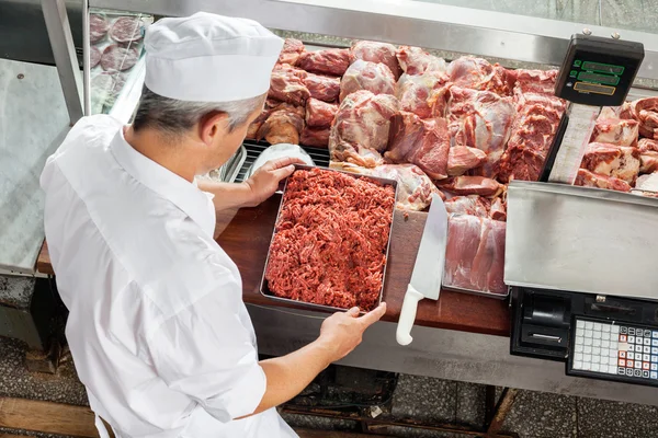 Slaktaren Holding malet kött bricka — Stockfoto