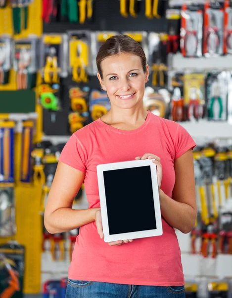 Mulher mostrando tablet digital na loja de ferragens — Fotografia de Stock