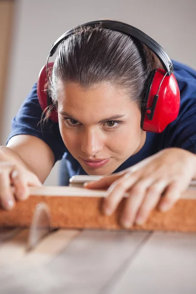 Koncentrovaná Carpenter řezání dřeva s Tablesaw — Stock fotografie