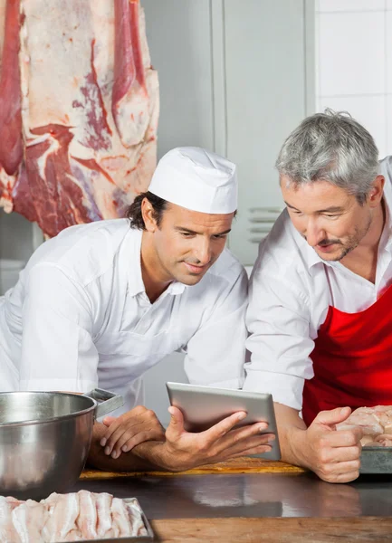 Butchers Using Tablet Computer At Counter — Stock Photo, Image