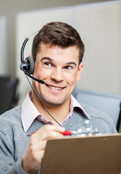 Representante de servicio al cliente con portapapeles mirando hacia otro lado — Foto de Stock