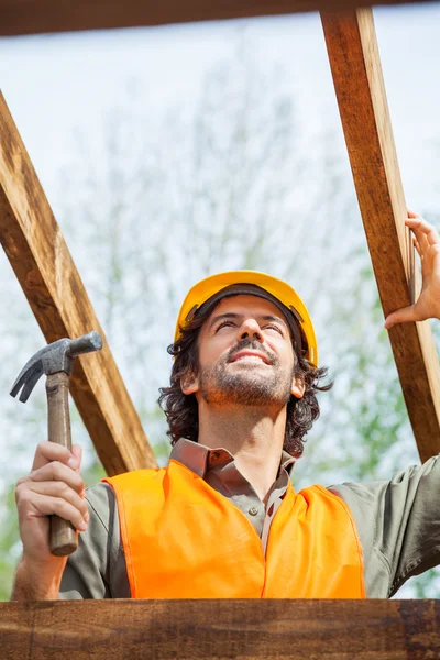 Trabalhador de construção segurando martelo no local — Fotografia de Stock