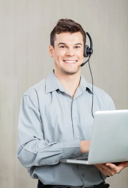 Männlicher Callcenter-Mitarbeiter mit Laptop — Stockfoto