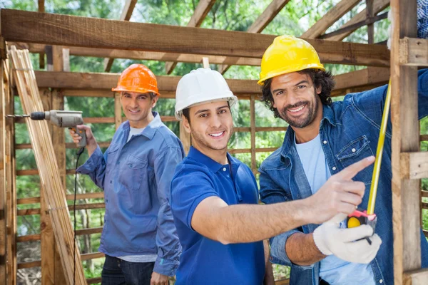 Trabalhadores da construção feliz que trabalham na cabine de madeira — Fotografia de Stock