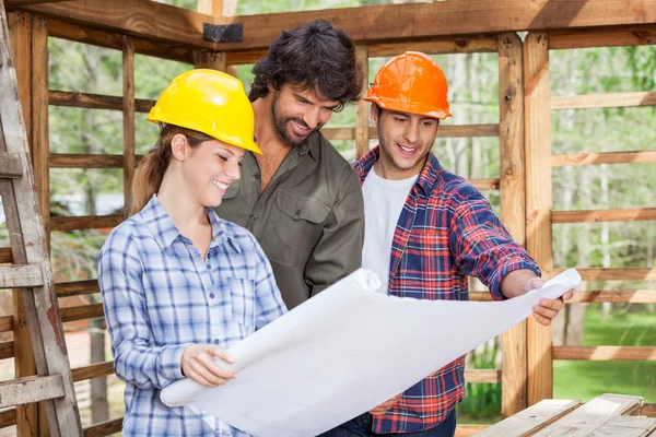 Arquitectos sonrientes discutiendo sobre el proyecto en el sitio — Foto de Stock