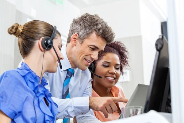 Manager mit Führungskräften im Kundendienst, die Tablet-Computer verwenden — Stockfoto